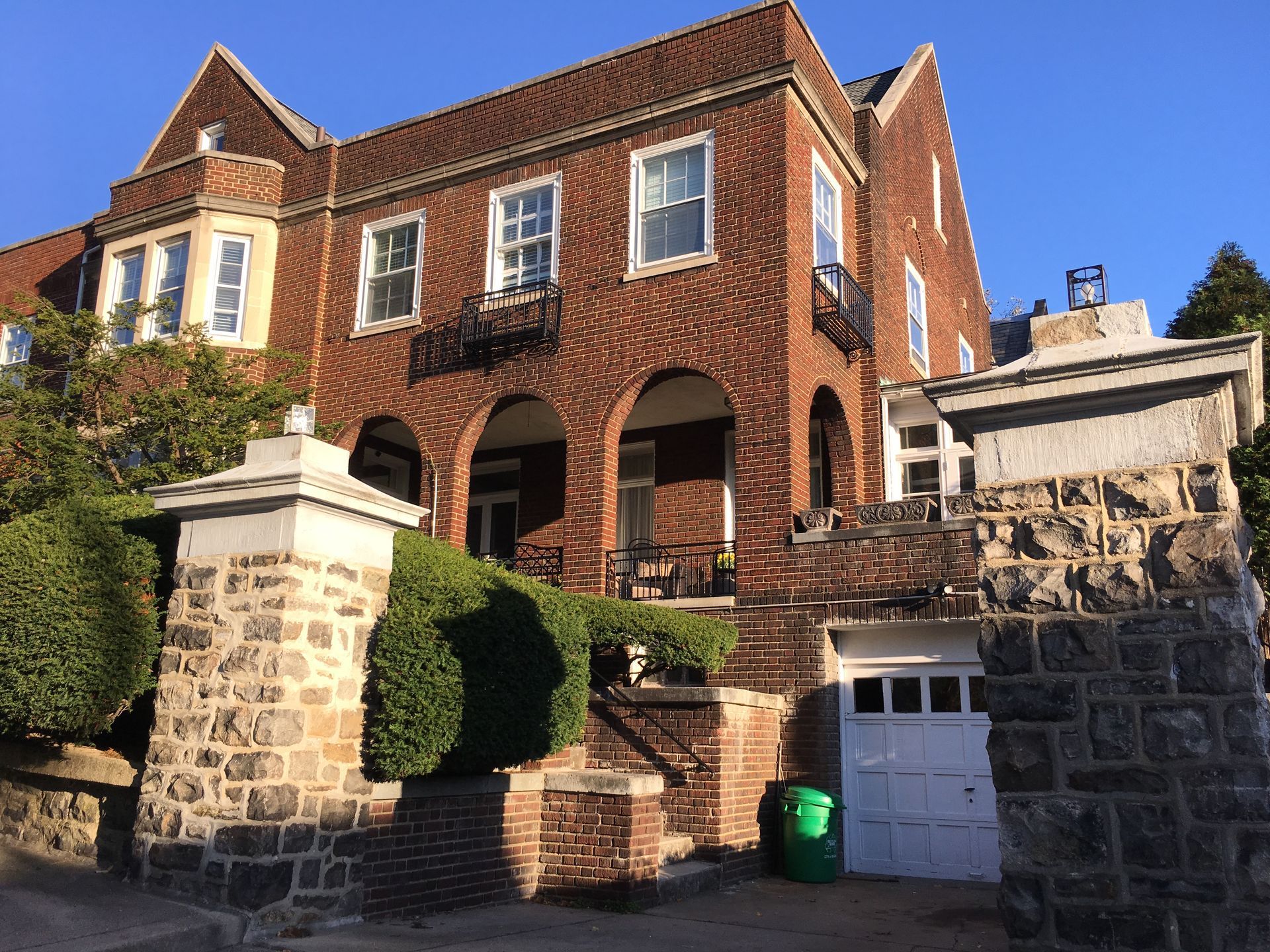A large brick building with a green trash can in front of it