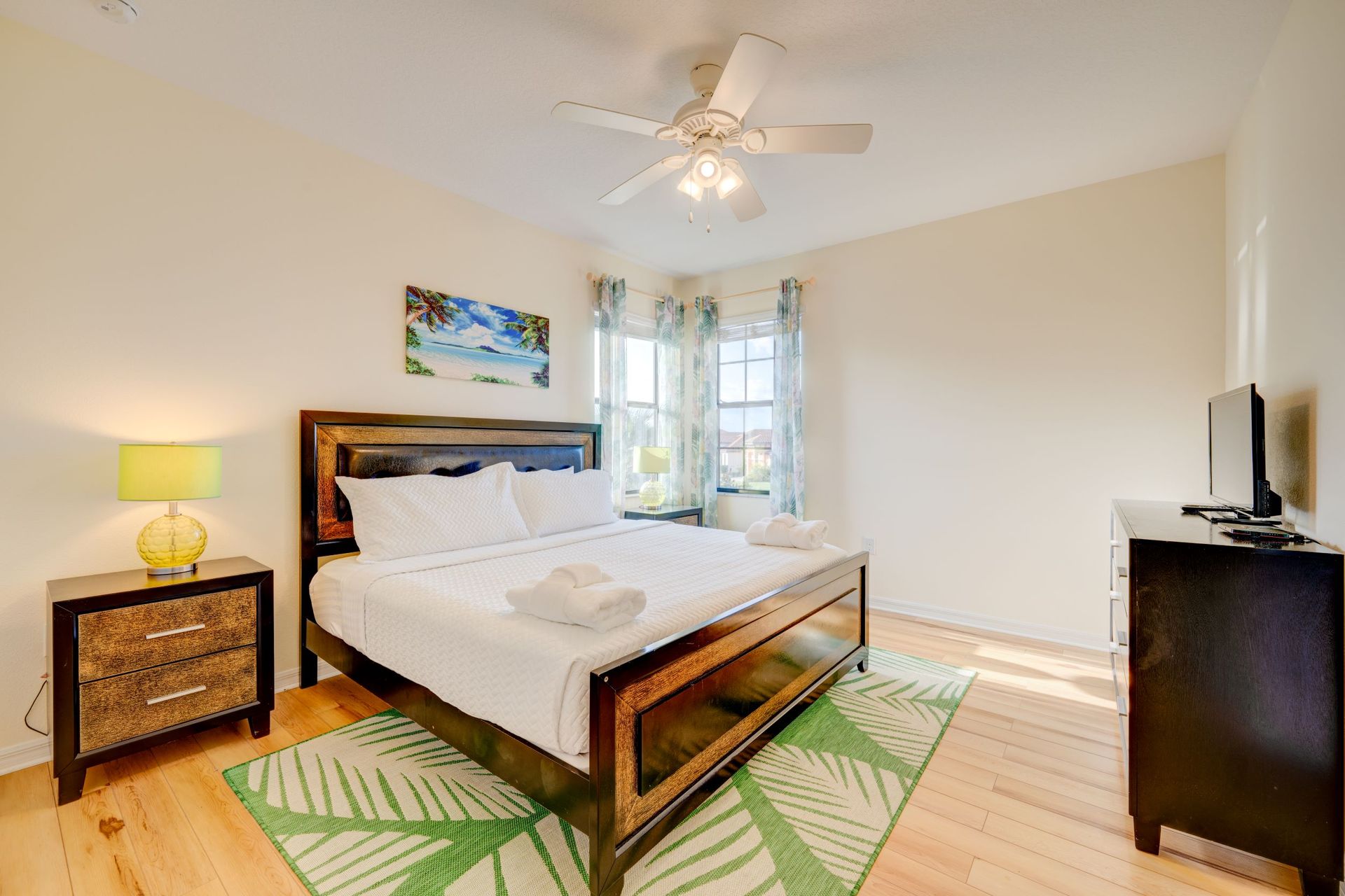 A bedroom with a king size bed , nightstand , dresser and television.