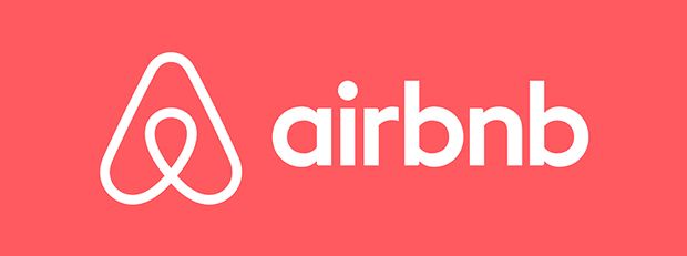 The airbnb logo is on a red background.