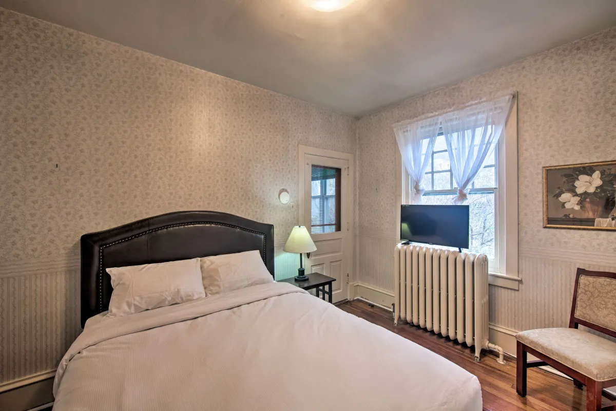 A bedroom with a bed , chair , lamp and television.