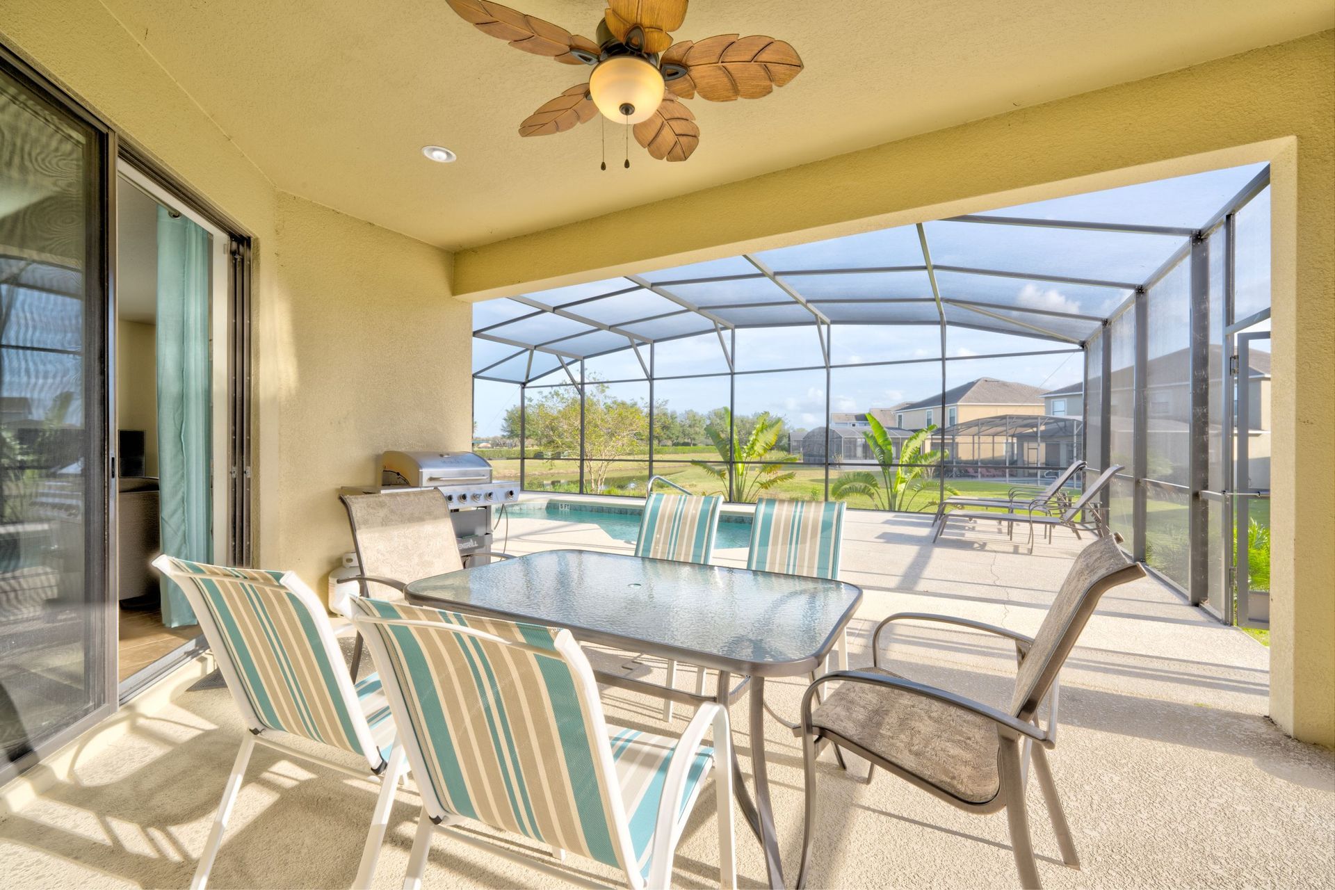 A patio with a table and chairs and a ceiling fan.
