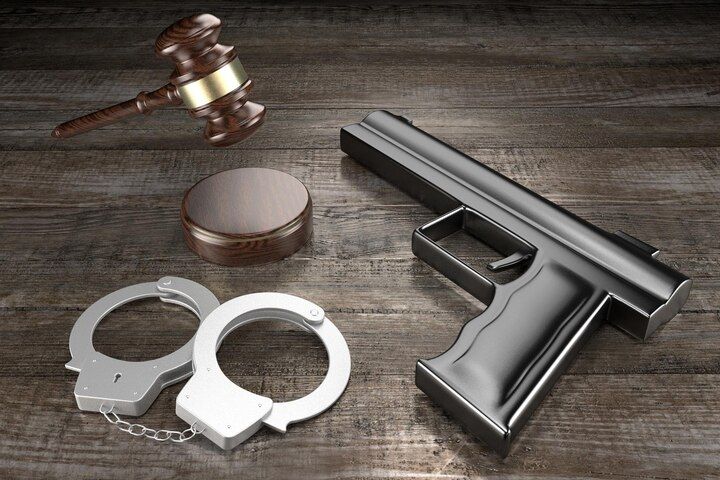 Gavel, sound block, handcuffs, and a handgun on a wooden surface. Firearm During Dangerous Felony in Nashville, Tennessee