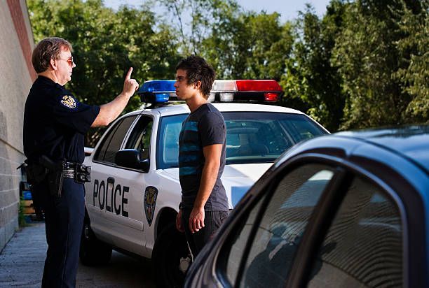 Police officer pointing at a person next to a police car and another car, outdoors. Freeman & Fuson Trial Lawyers in Nashville, Tennessee