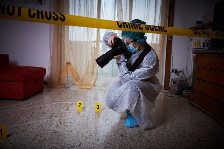 Forensic photographer at a crime scene, taking photos with camera. Yellow tape and evidence markers present. Criminally Negligent Homicide in Nashville, Tennessee