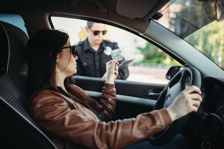 Woman in car receives a citation from a police officer. Driving on Suspended License in Nashville, Tennessee