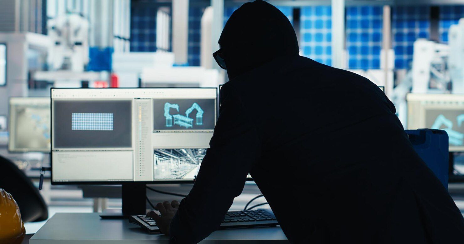 Person in a dark hoodie looking at a computer screen in a lab setting, likely controlling robotics. Theft of Services in Nashville, Tennessee