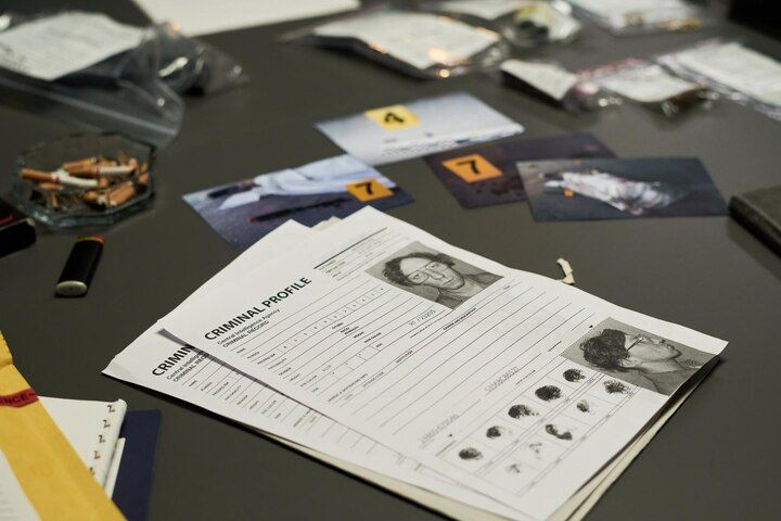Crime scene investigation: criminal profile documents, photos, and evidence bags on a table. Second Degree Murder in Nashville, Tennessee