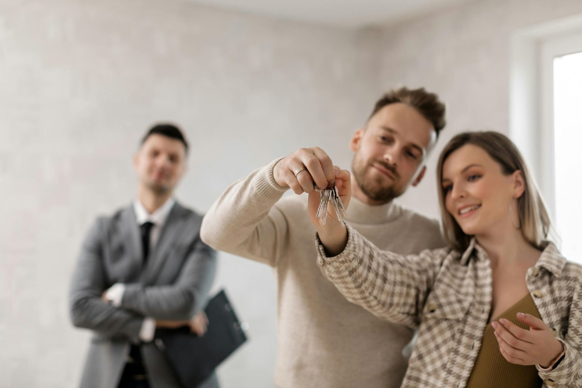 Couple receiving keys from the seller in a new home; real estate agent watches. Landlord Tenant Disputes in Nashville, Tennessee
