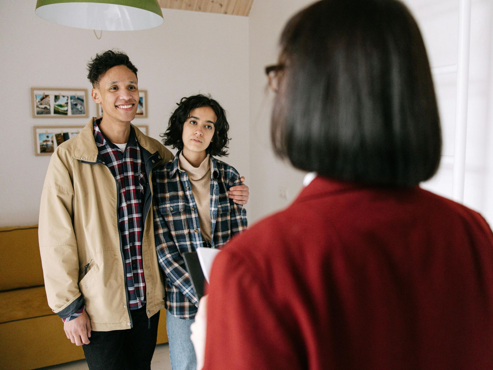 Couple with real estate agent indoors, looking at a home. Agent is holding paperwork. Landlord Tenant Disputes in Nashville, Tennessee