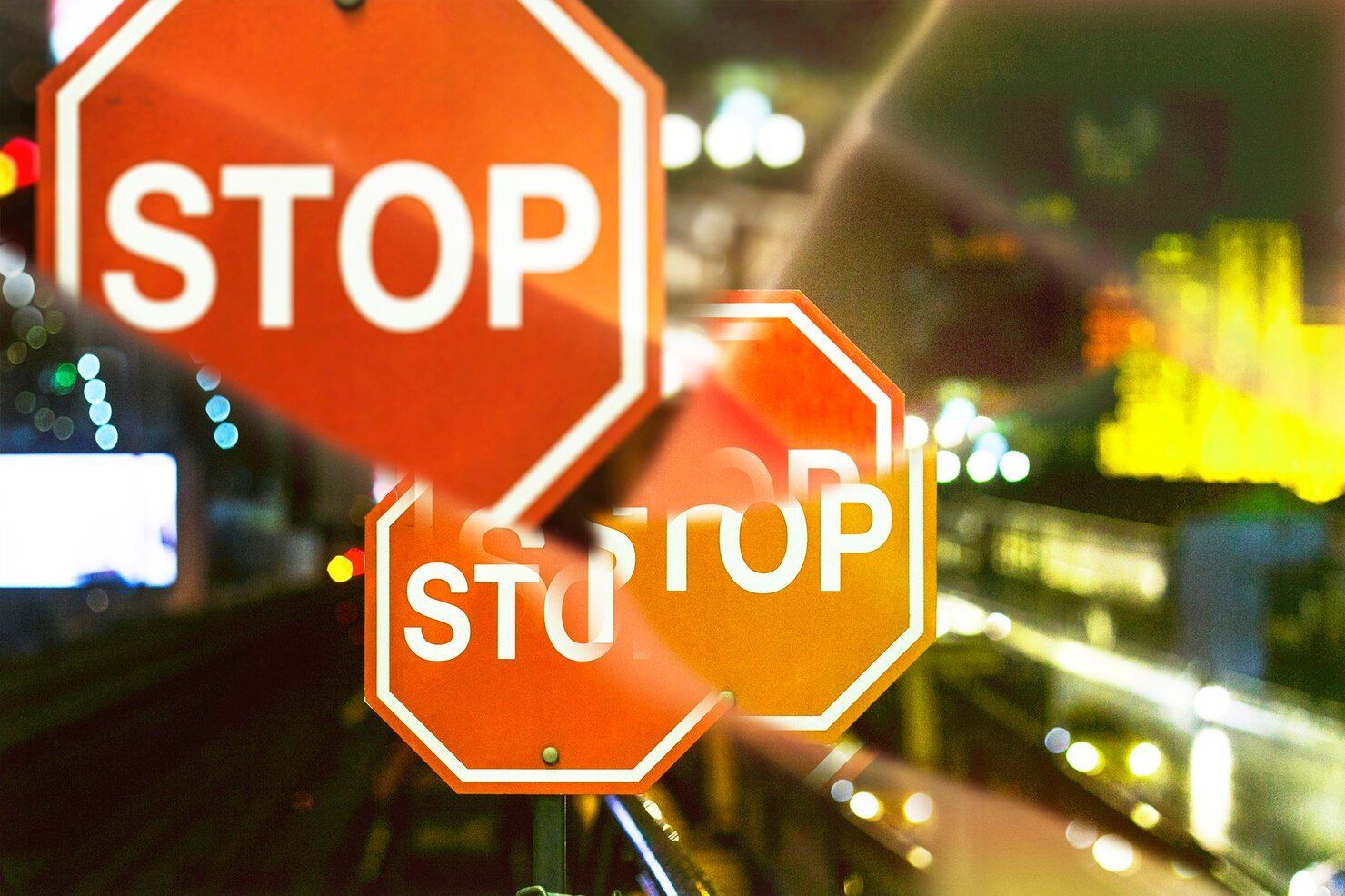 Multiple stop signs, blurred urban background. Traffic Violations / CDL in Nashville, Tennessee
