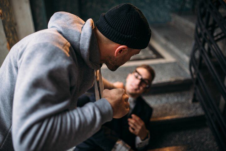Man in gray hoodie confronting another man on stairs; fists raised. Crimes Against the Person in Nashville, Tennessee