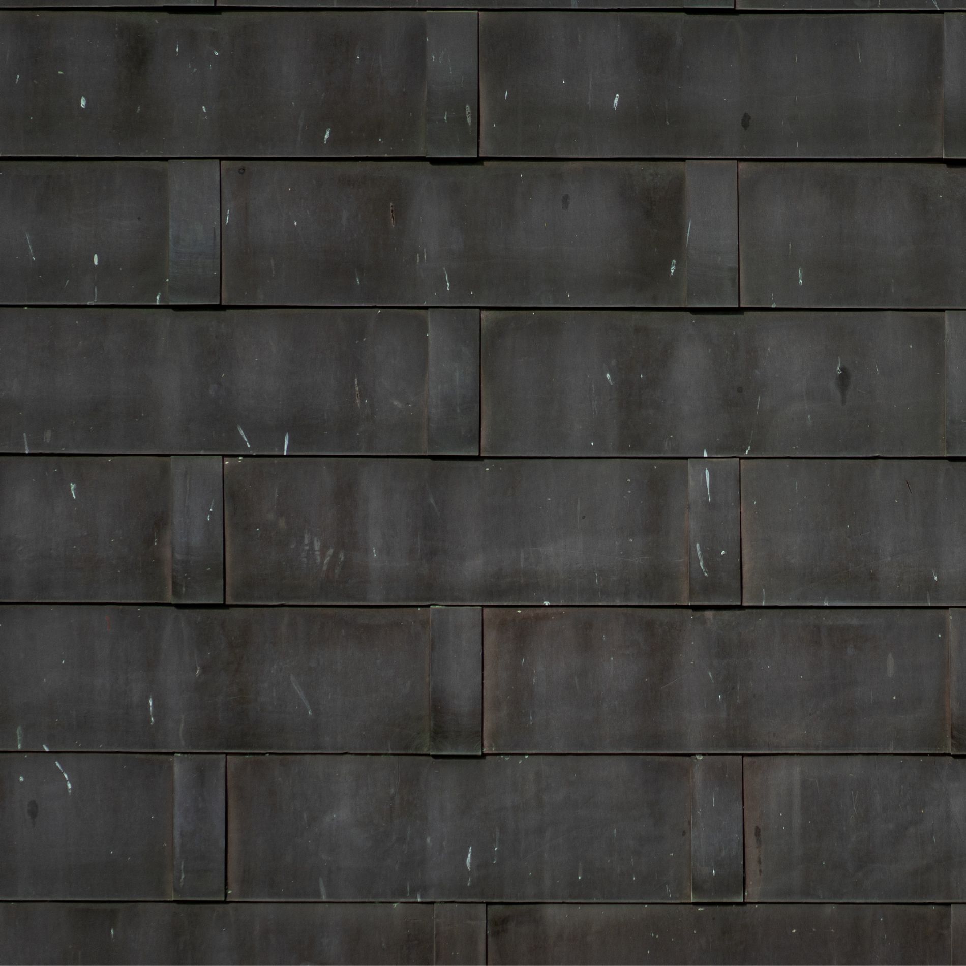 Dark, weathered brick wall with a rectangular pattern.