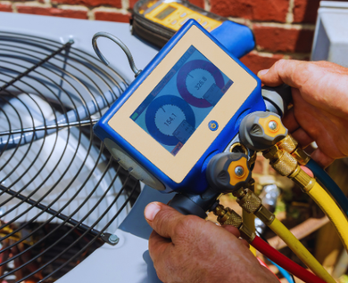 A man is working on an air conditioner with a digital device