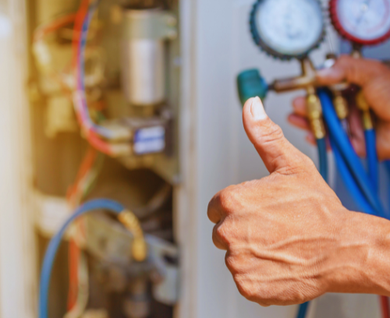 A person is giving a thumbs up while working on an air conditioner.