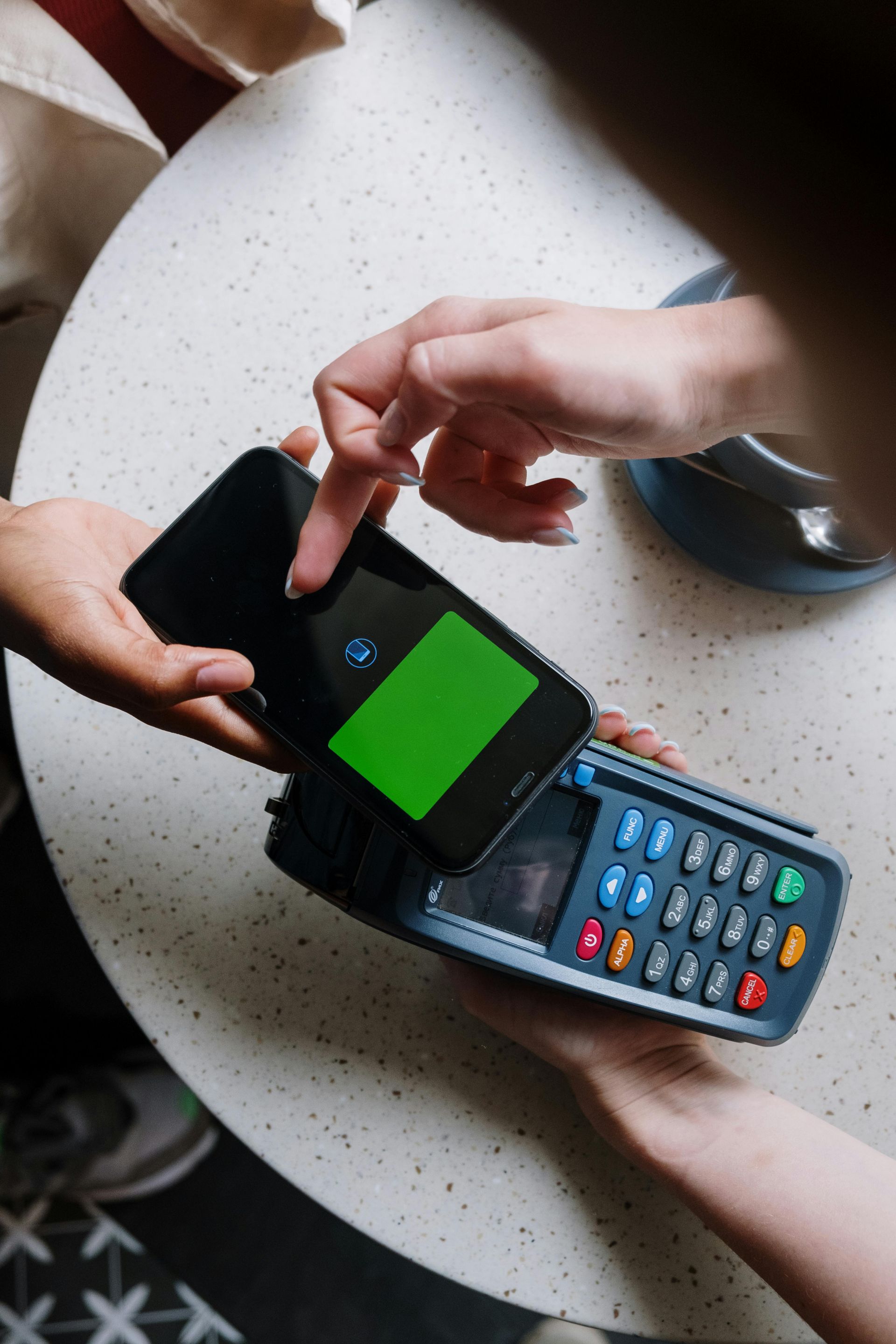 Person paying with smartphone via NFC terminal.