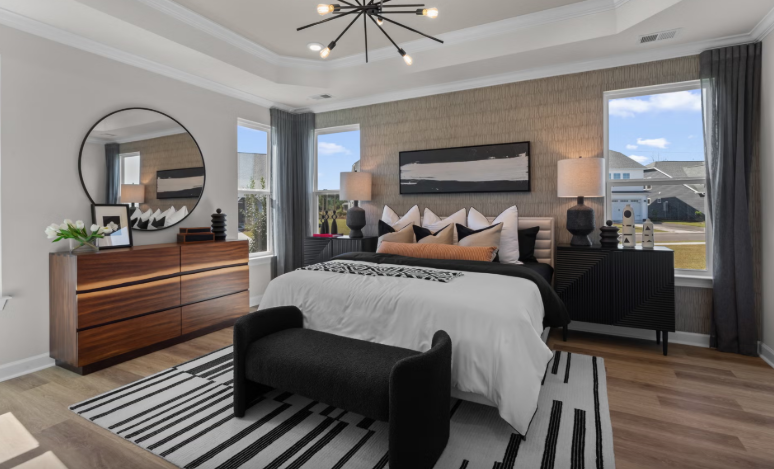 Modern master bedroom with king bed, dresser, and black and white accents.