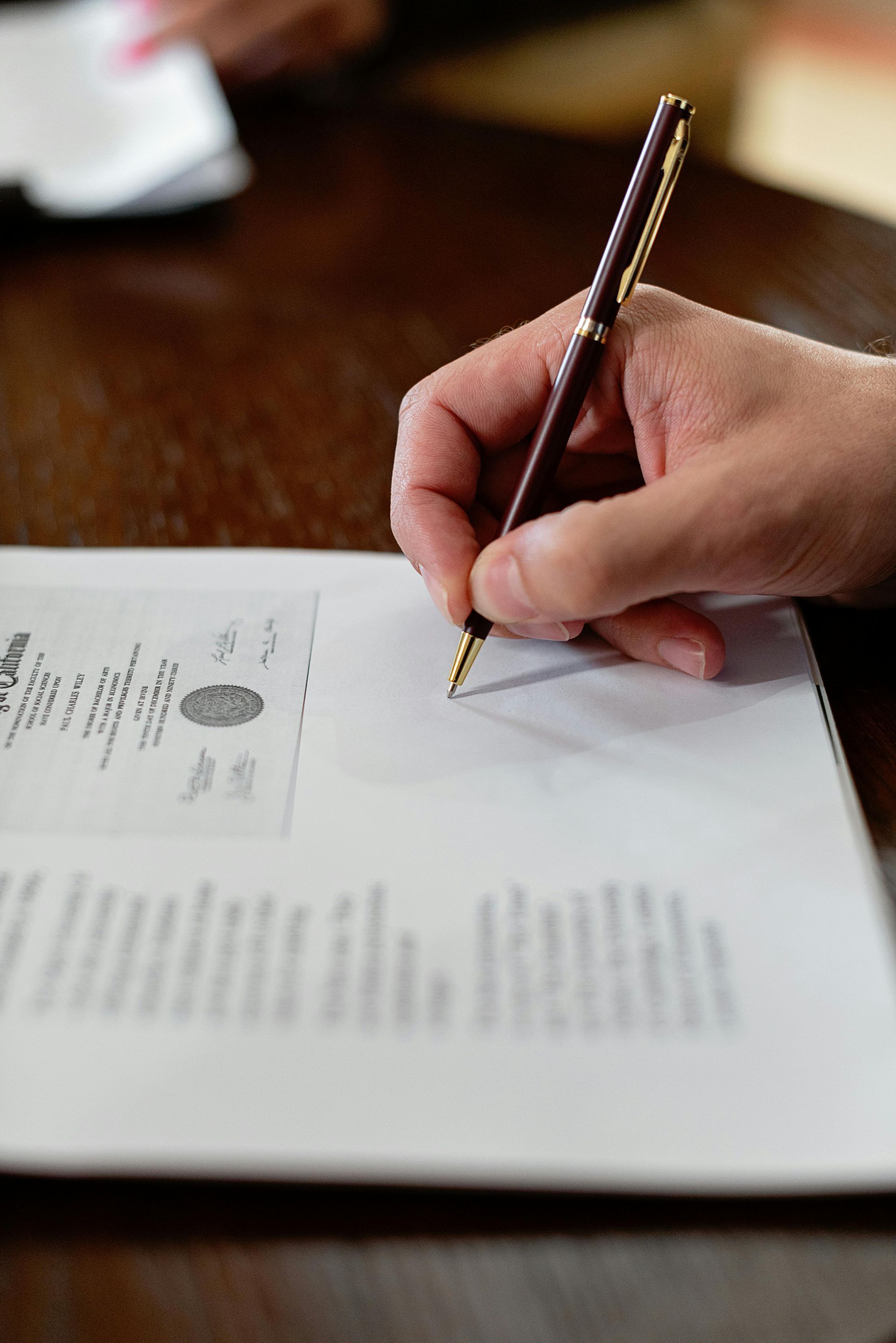 A person is writing on a piece of paper with a pen