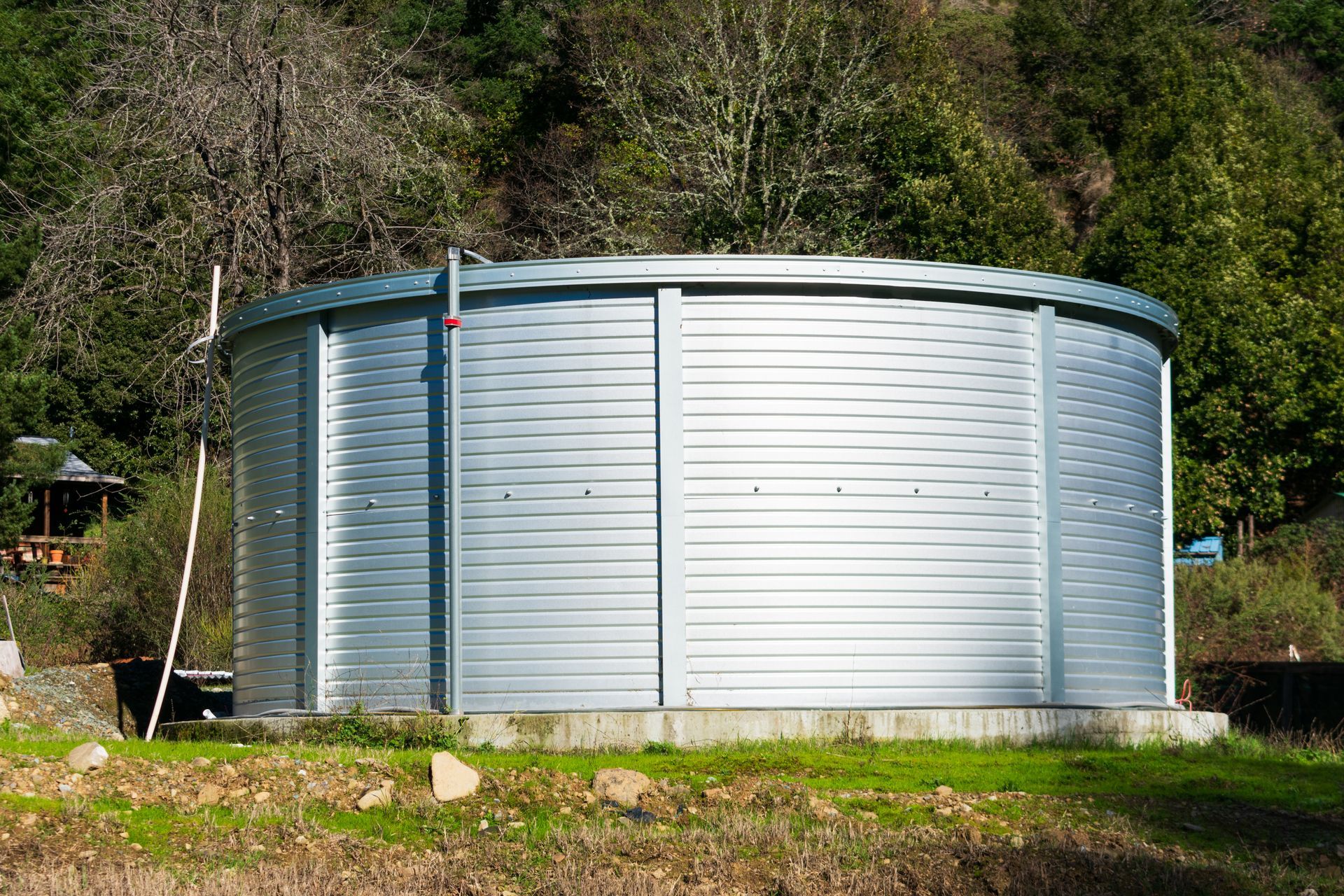 A large capacity corrugated steel water tank in a rural neighbourhood. A large capacity corrugated steel water tank in a rural neighbourhood.