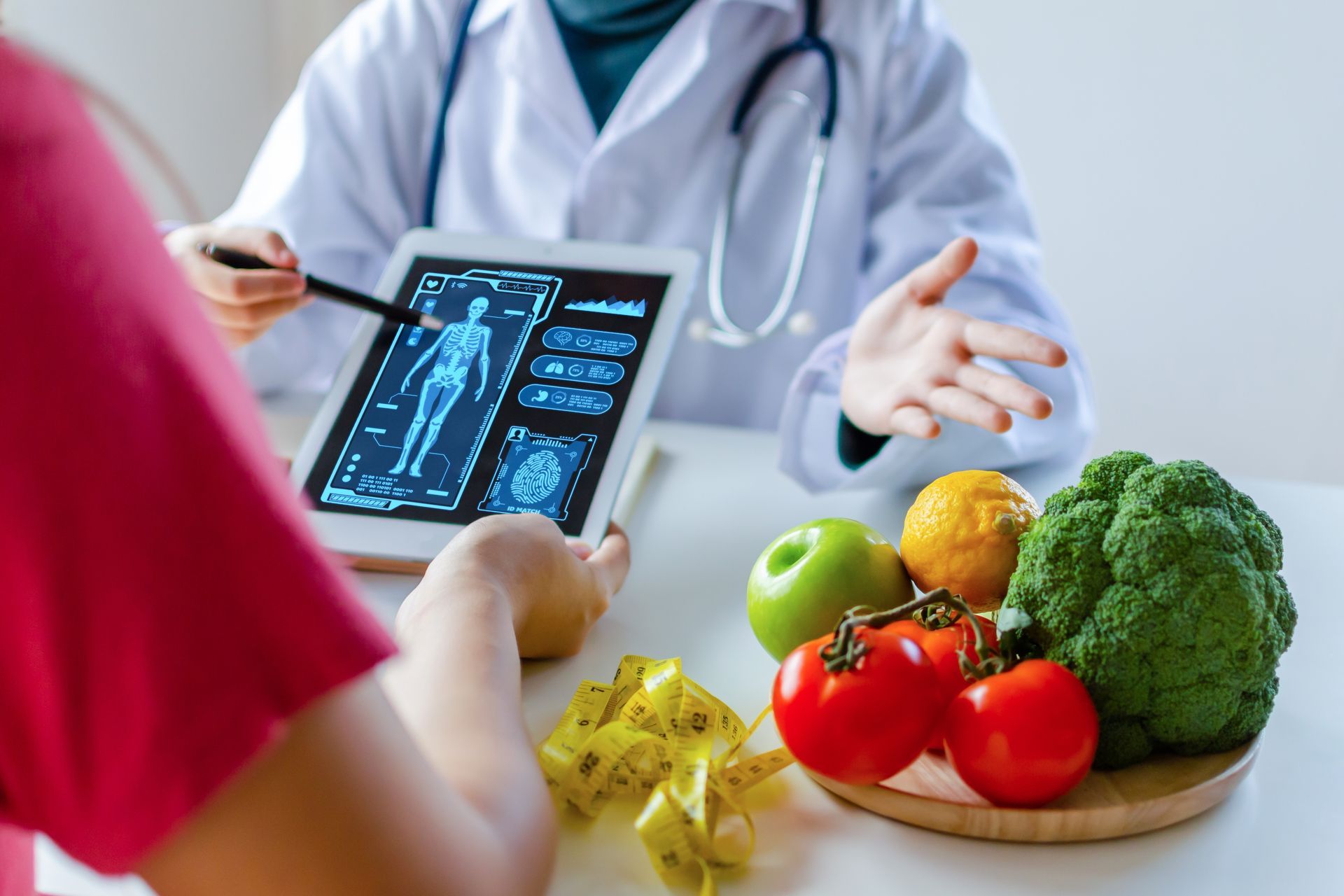 Doctor discussing body scan results with a patient, fruits and vegetables on the table.