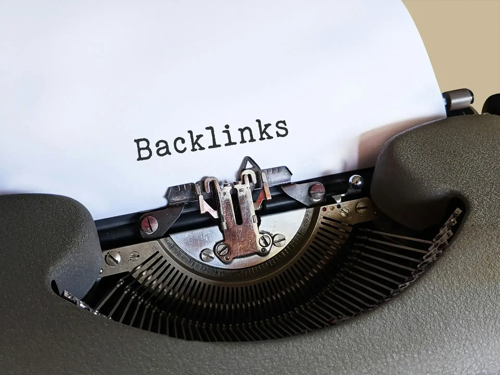 The word backlinks is typed on a typewriter demonstrating SDL usage of backlinking in our SEO services.
