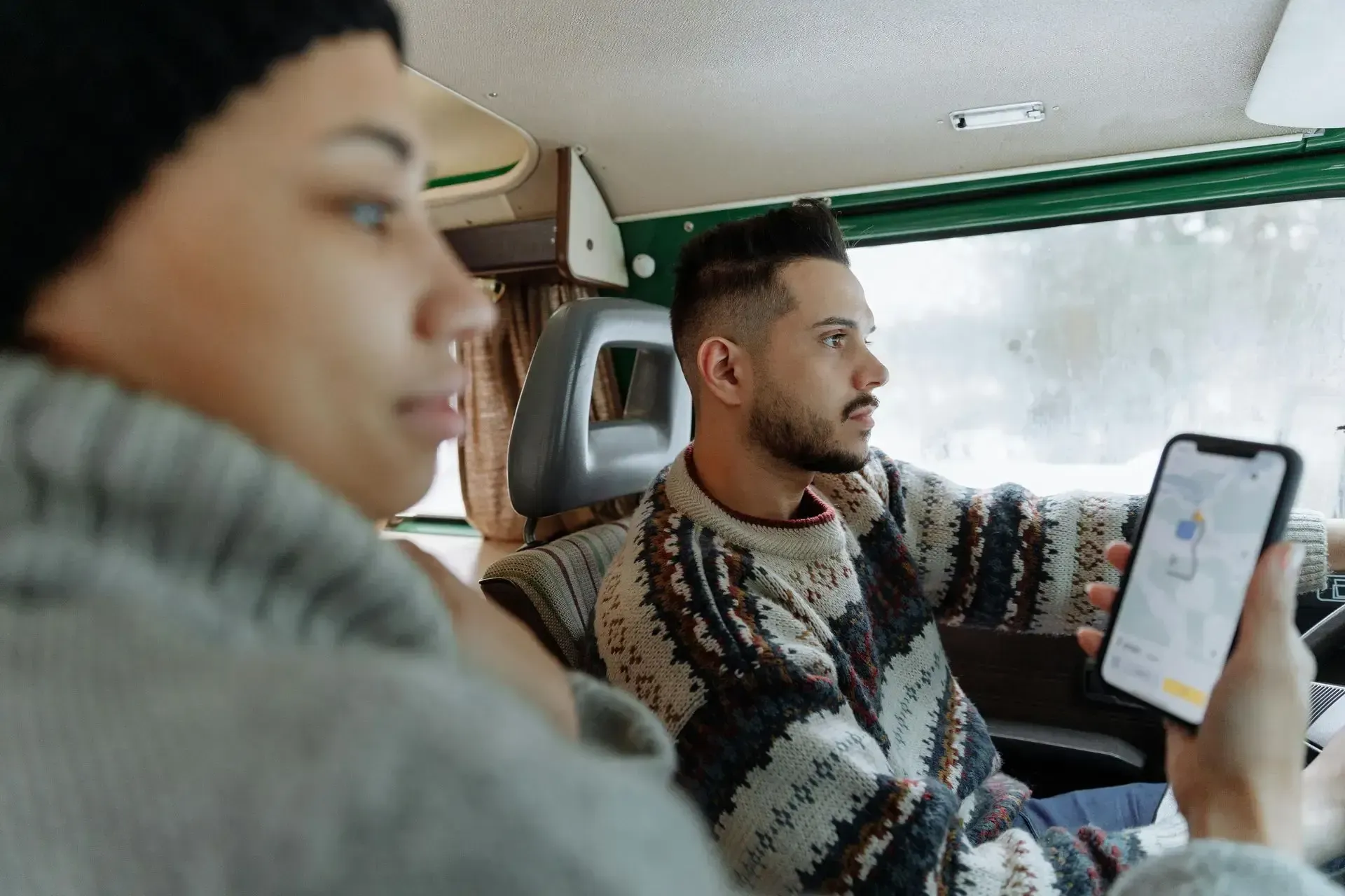 A man and a woman are sitting in a car using Google Maps to navigate to a business, which they found through the Map Pack.