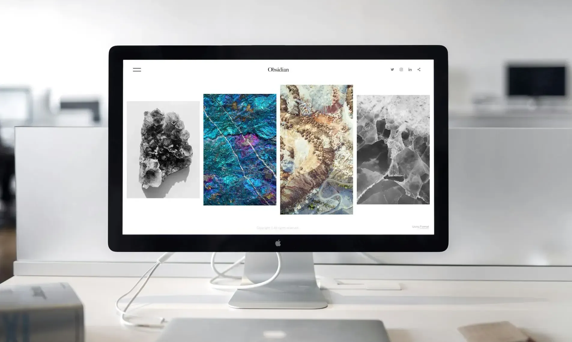 A computer monitor sits on a desk beside an SDL team member's laptop, displaying our website design service.