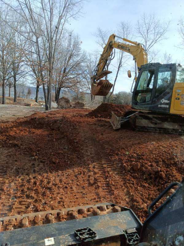 A yellow excavator is digging a hole in the dirt.