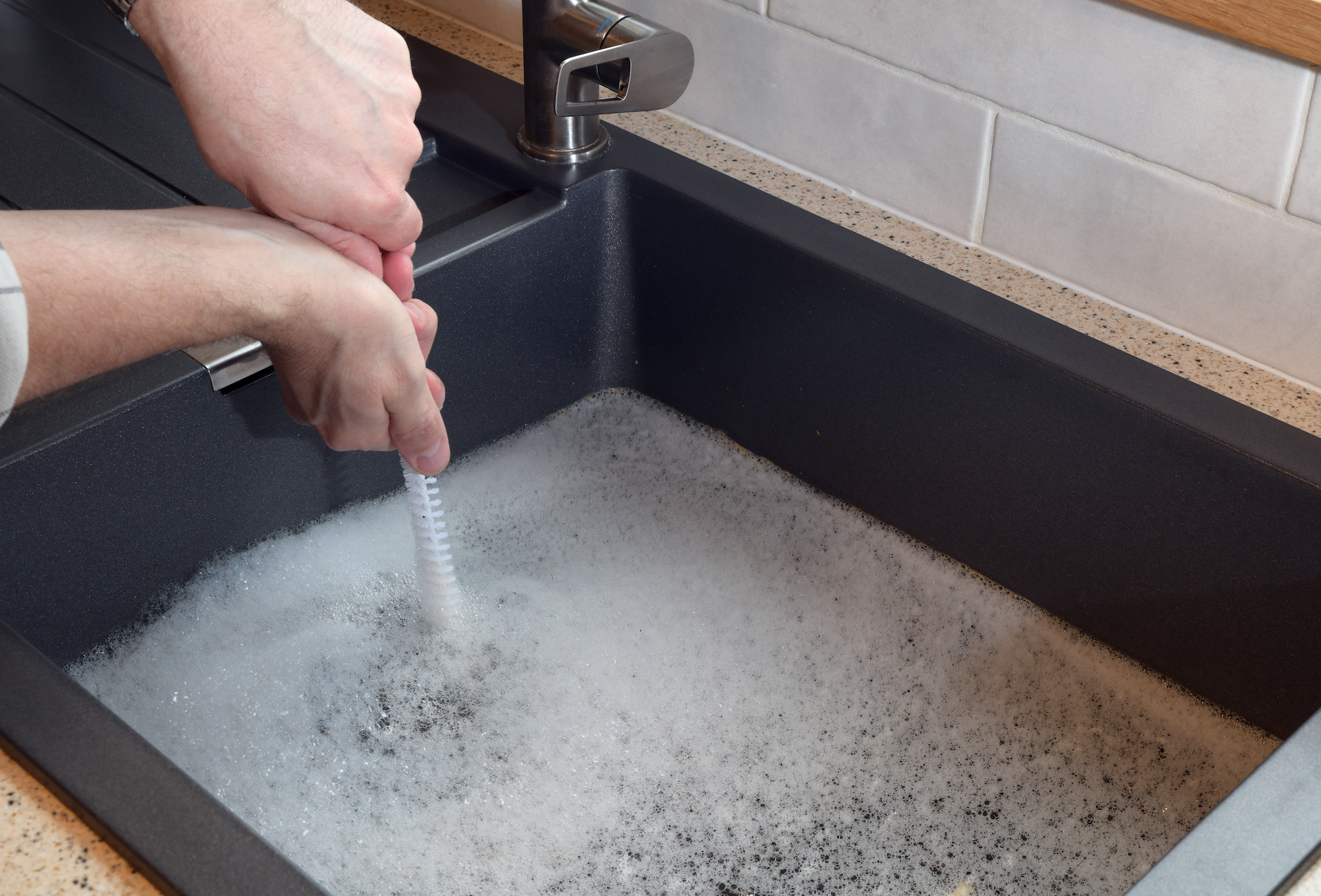 A person is cleaning a sink with a brush