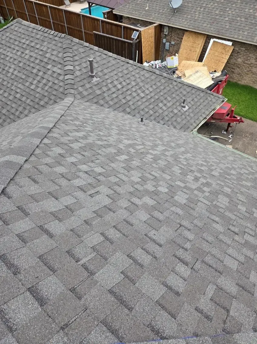Gray asphalt shingle roof on a house, angled view.