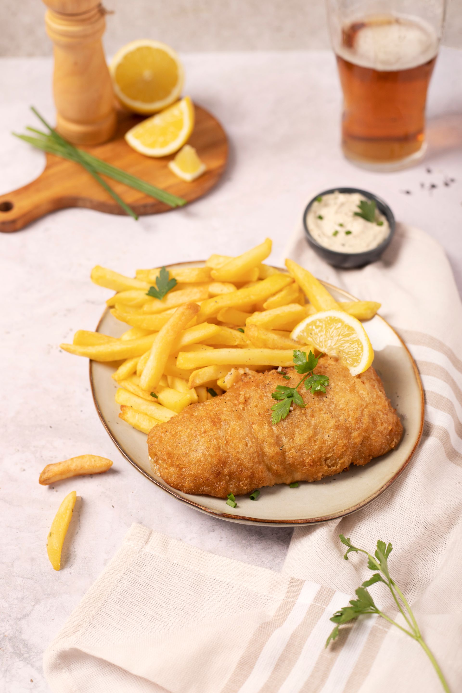 Filet de poisson pané fish and chips d'églefin en assiette avec frites et sauce tartare