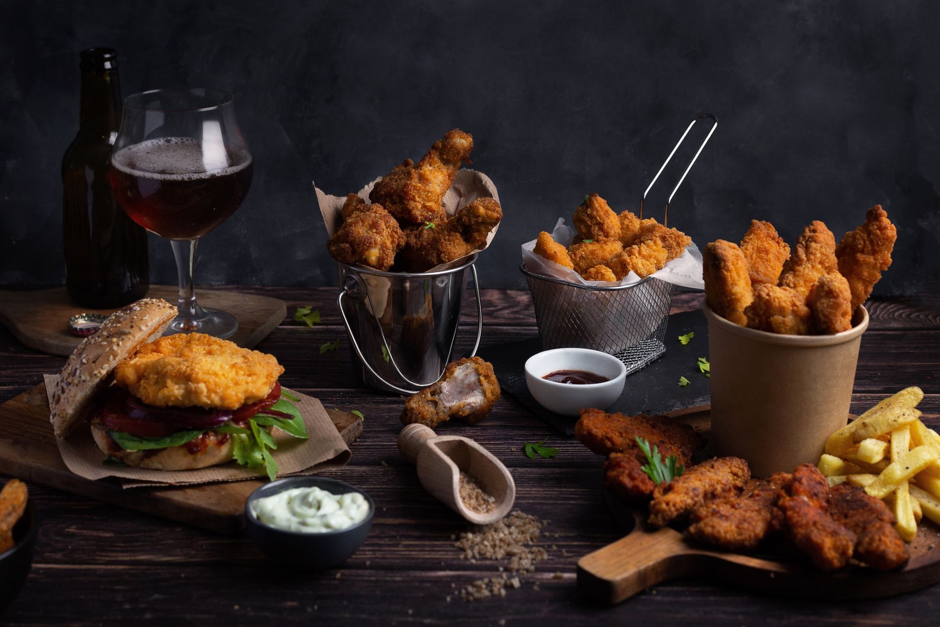 Une table garnie d'une variété d'aliments frits et d'un verre de bière.