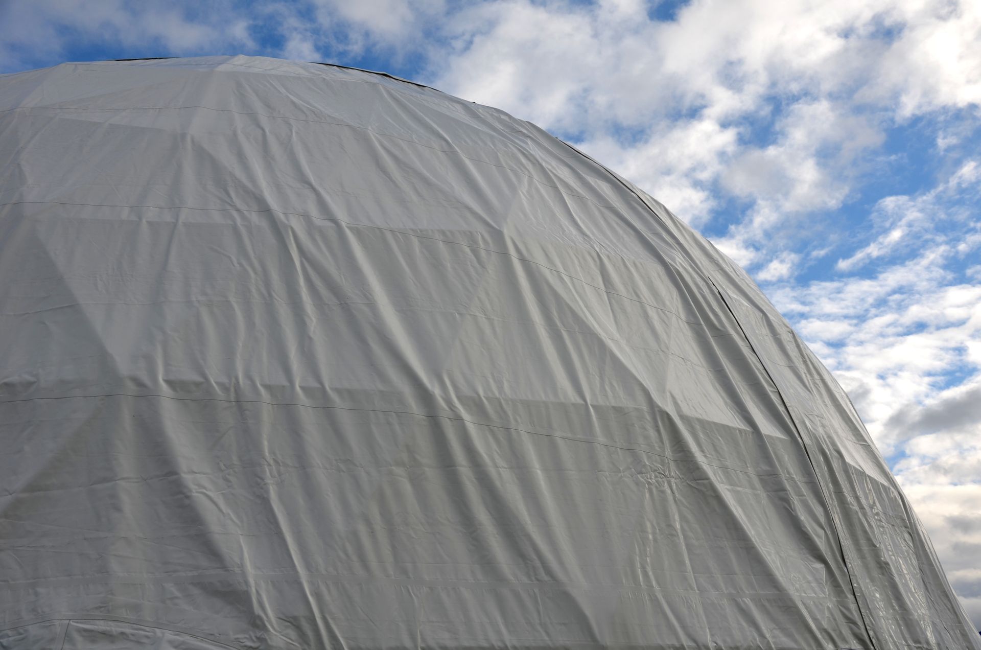 White dome structure against a partly cloudy sky.
