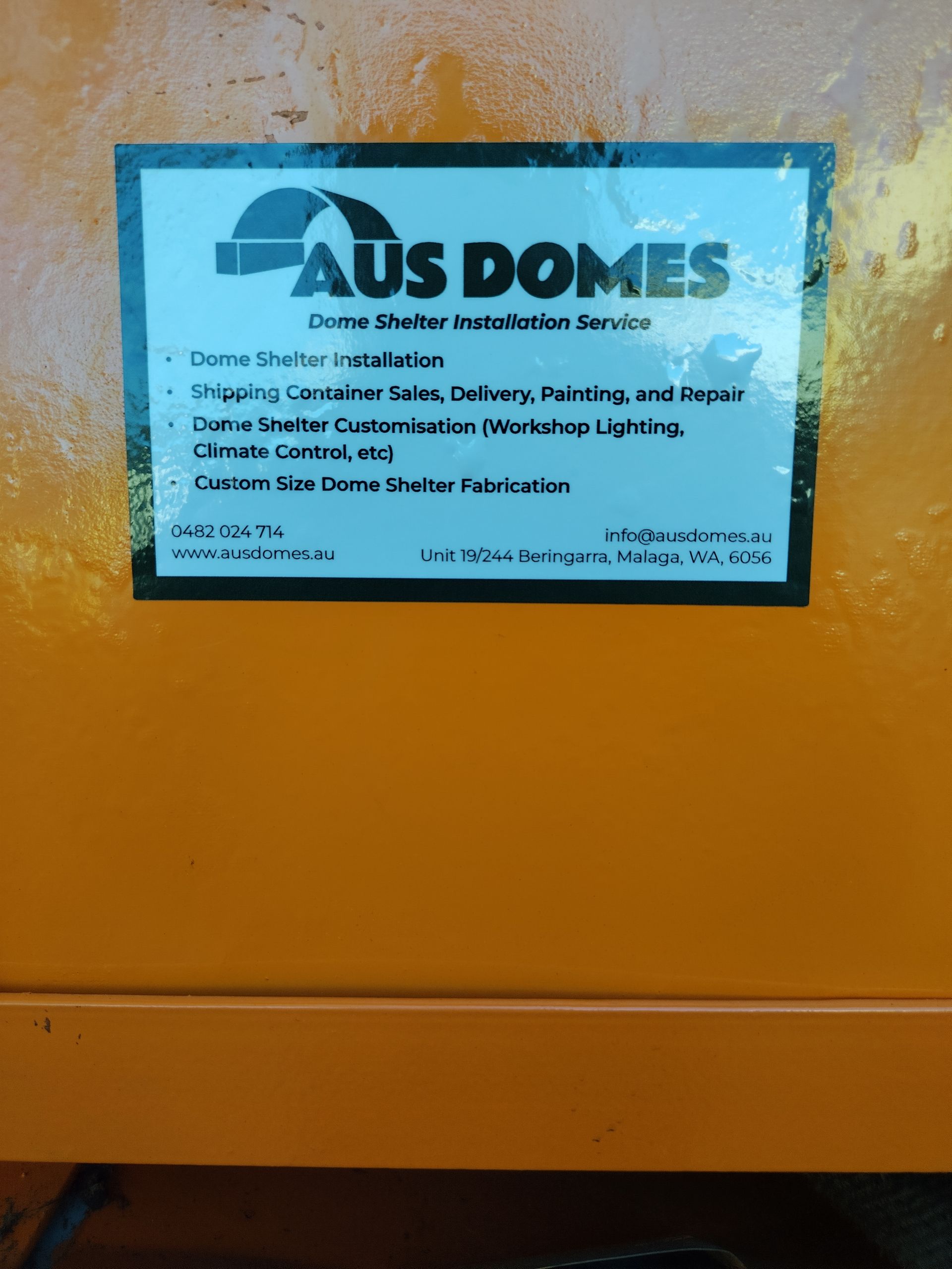 White geodesic domes on a wooden deck, with a transparent windowed section, set against a forest background.