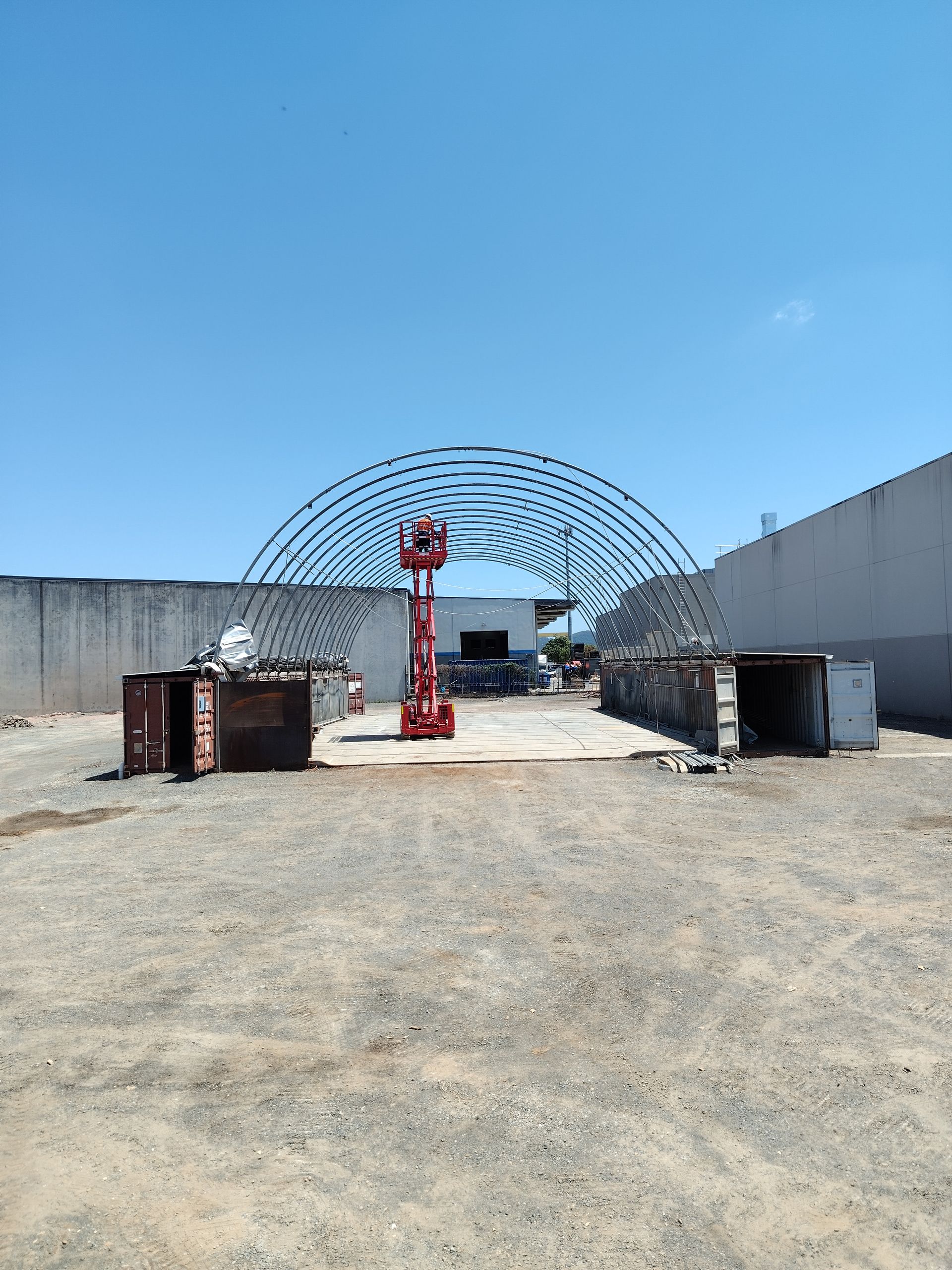 White geodesic dome structure with glass door on green grass.