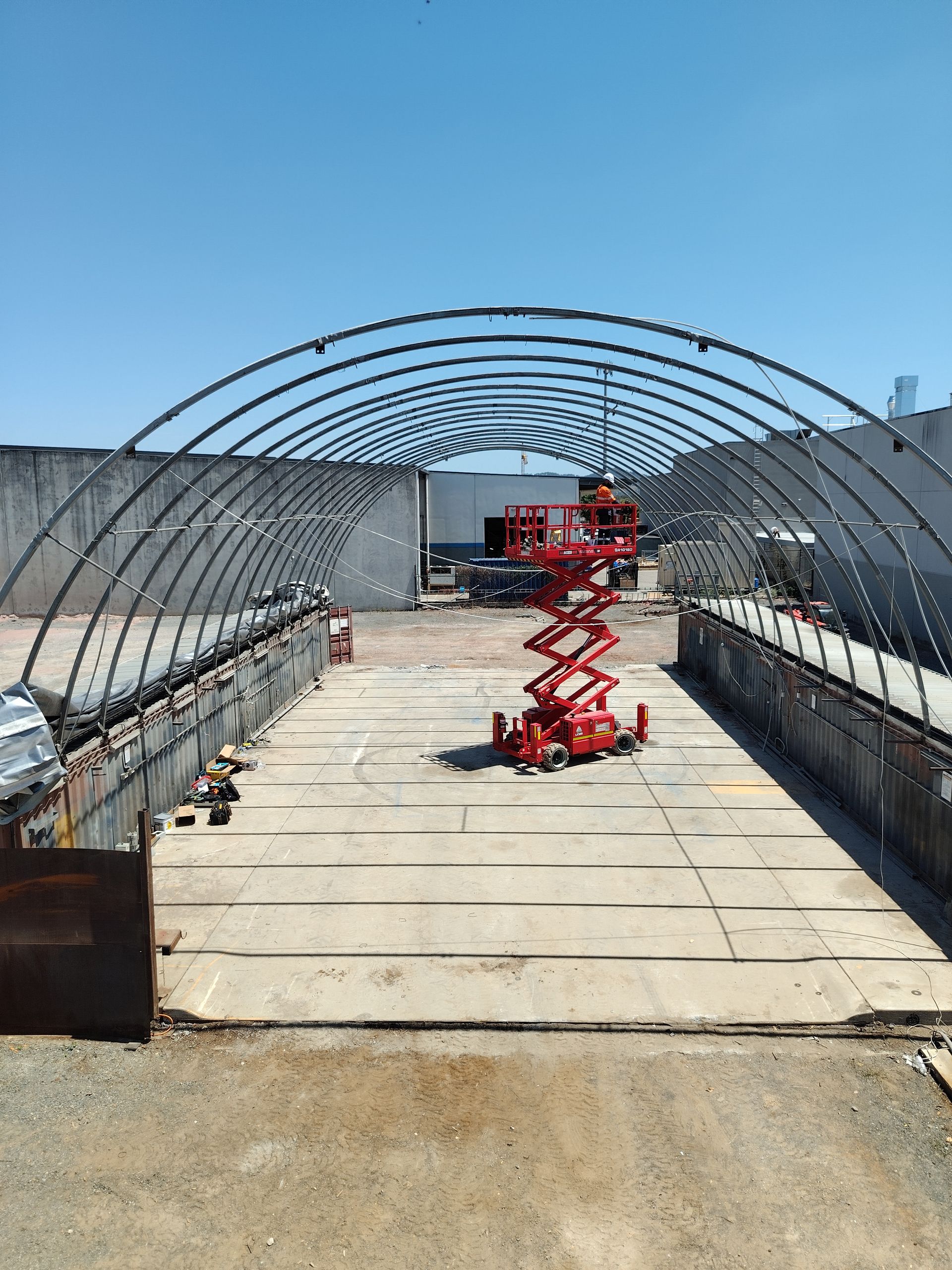 Cozy geodesic dome interior with wood-burning stove, bed, and view of outdoors.