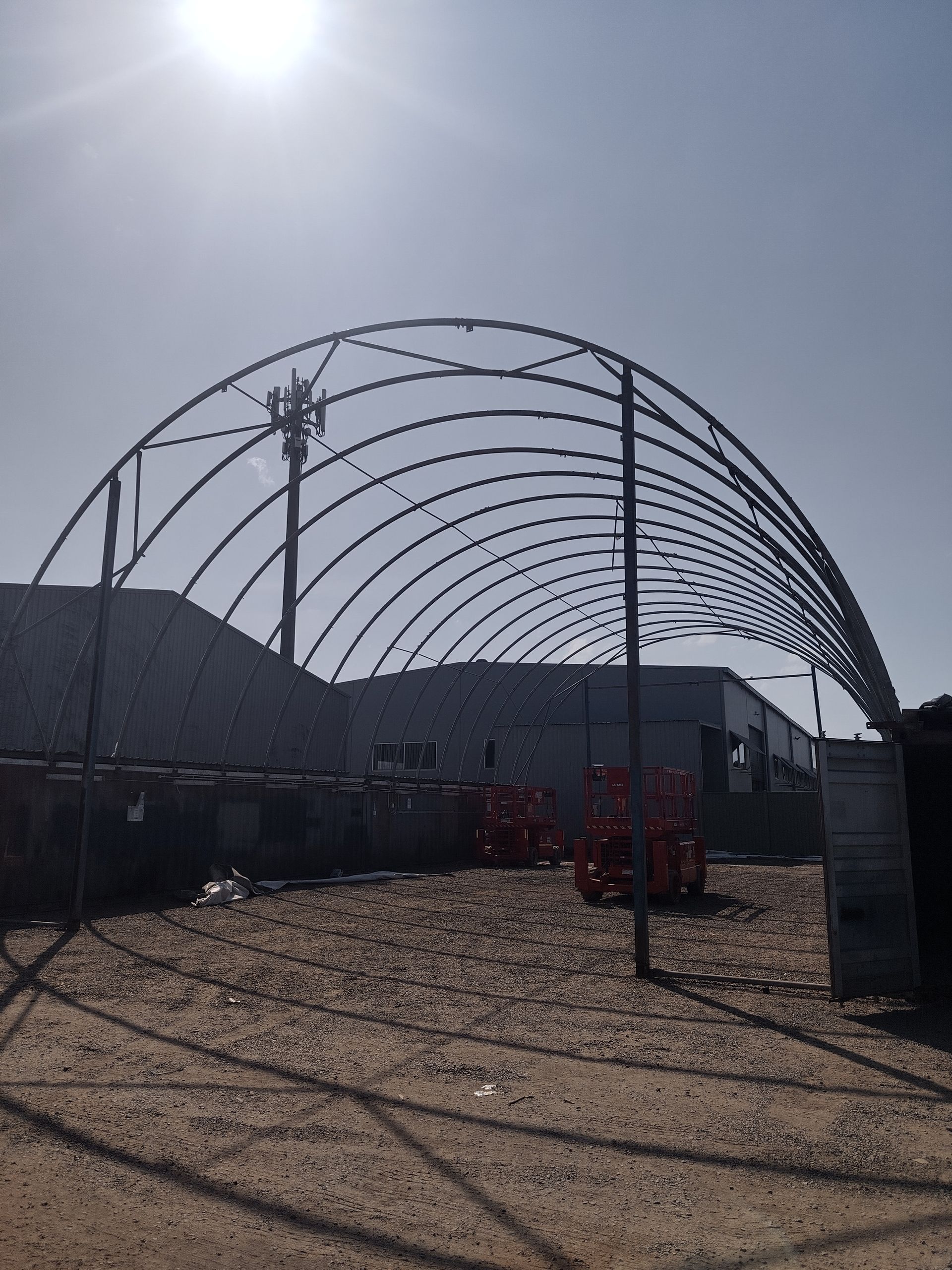 White canopy with black metal supports, wooden scaffolding.