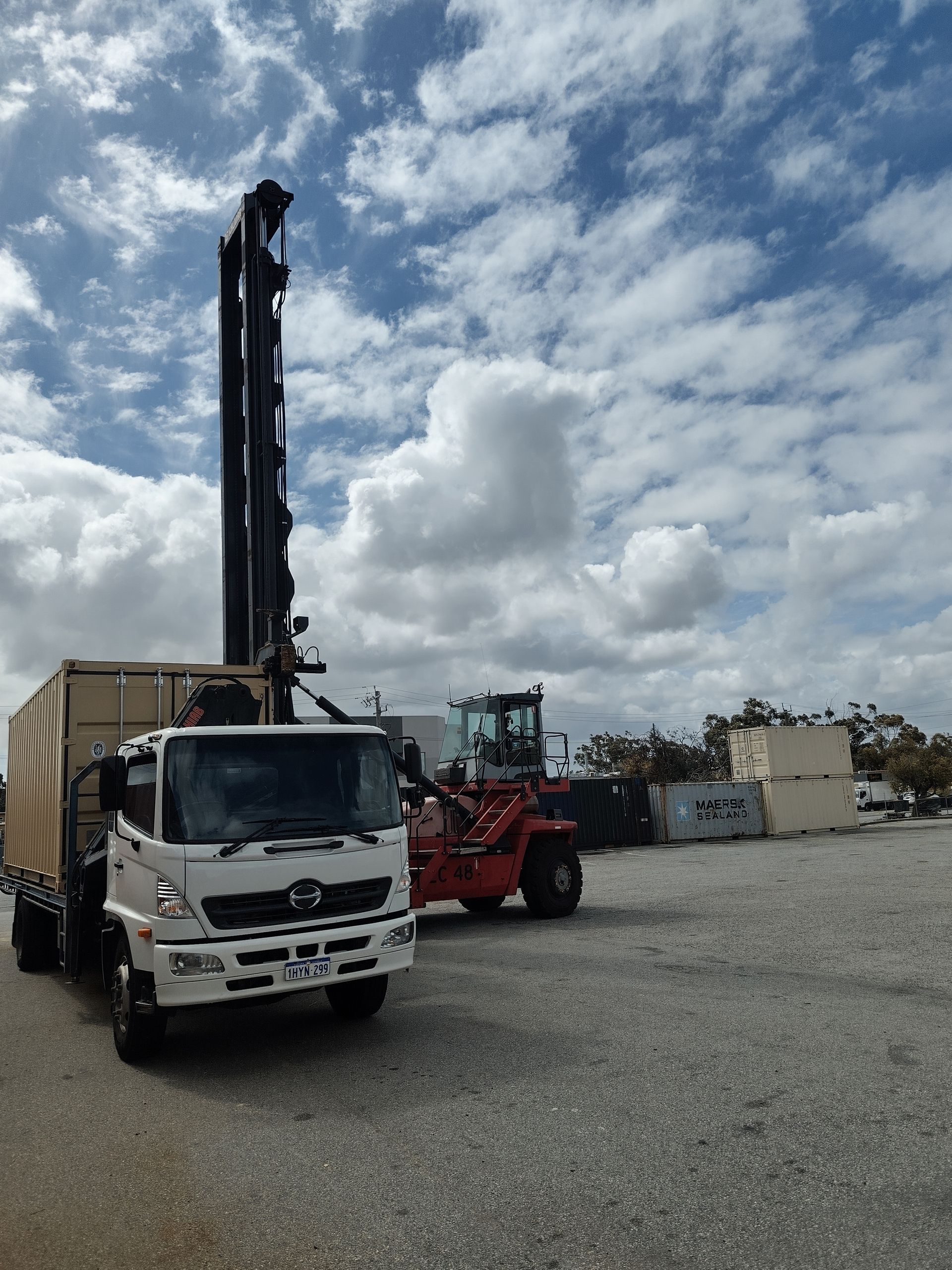 White event tent against a blue sky with fluffy clouds.