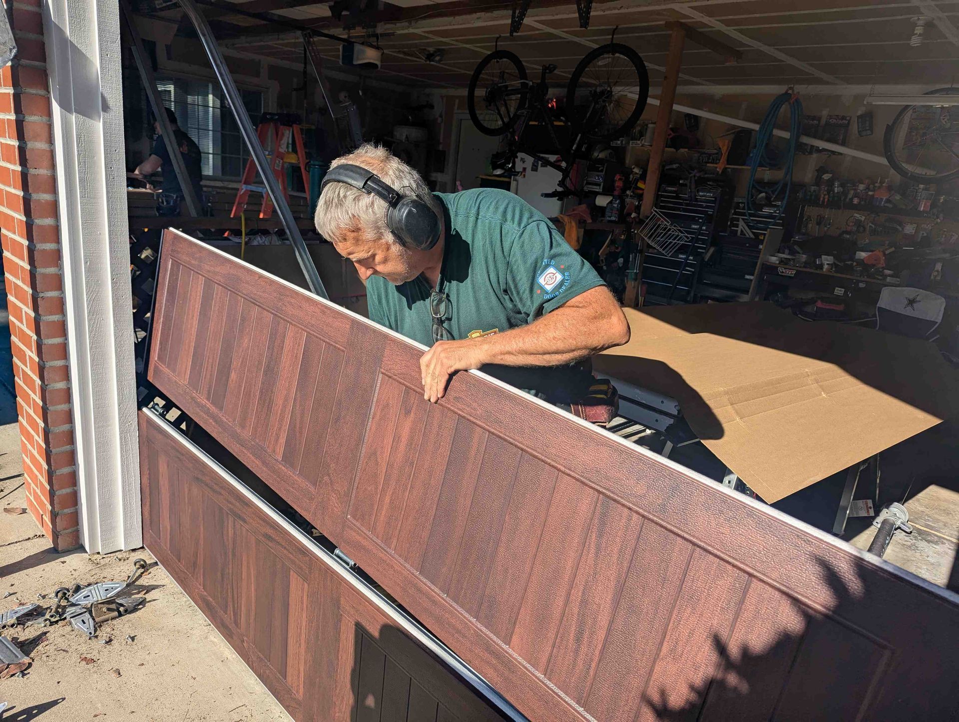 A man is fixing a garage door in a garage.