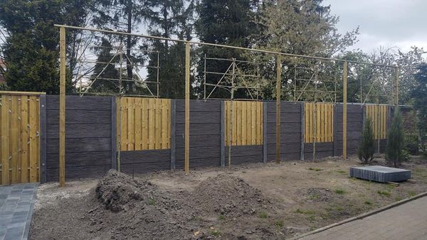 Combinatie van houten schuttingdelen en betonnen onderplaten, geplaatst door A&B Betonbouw.