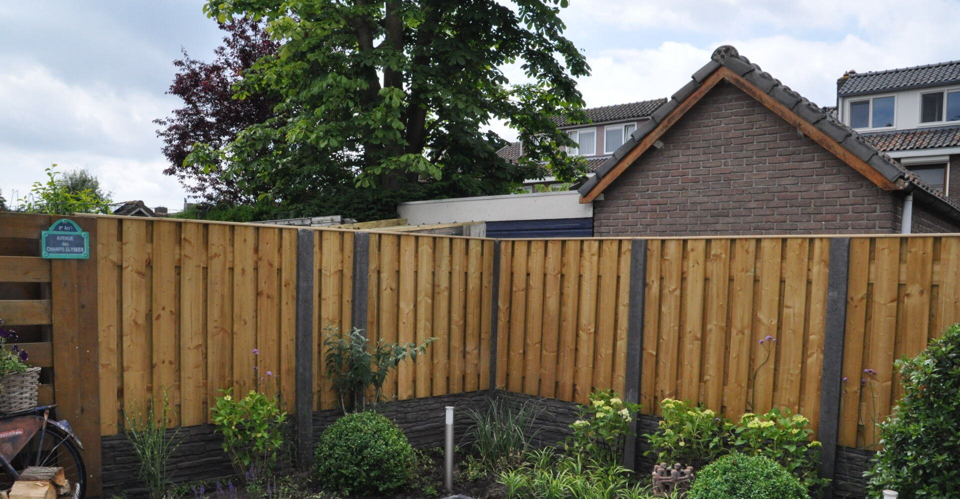 Houten schutting met antraciet betonnen palen, moderne tuinafscheiding van A&B Betonbouw.