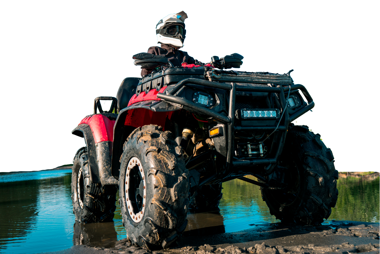 Red ATV in muddy water, person in helmet driving, off-road.