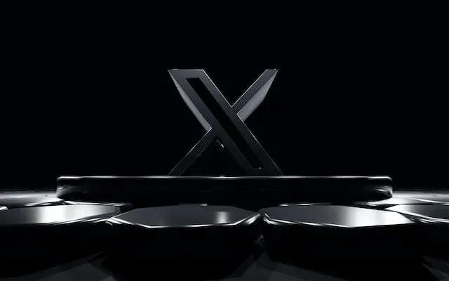 A black letter x is sitting on a black surface