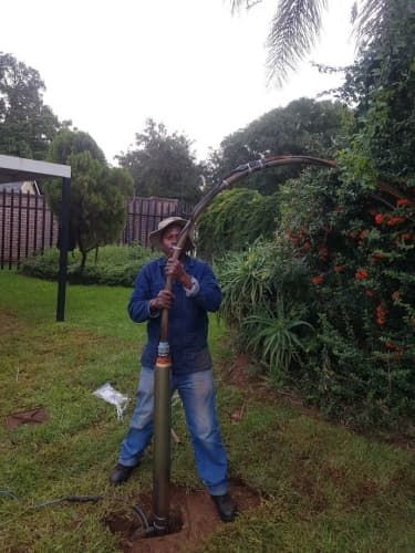 A drill bit is being used to drill a hole in the ground.