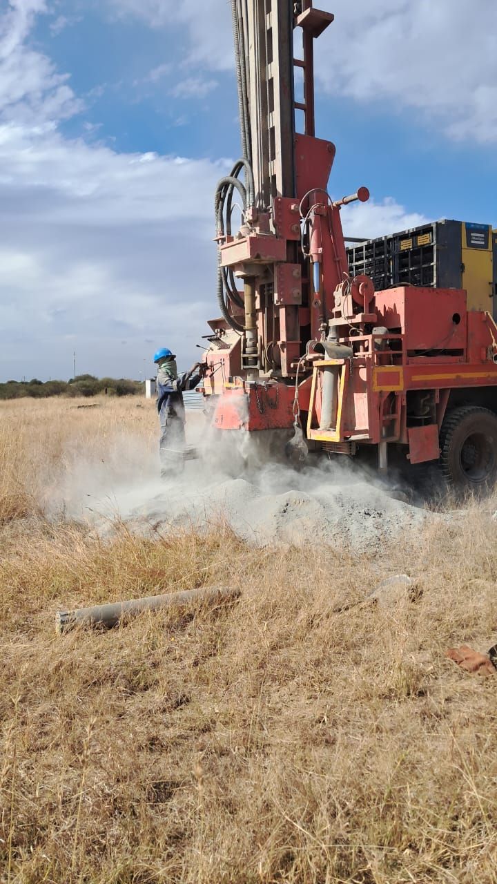 A man is standing next to a large machine in a field.
