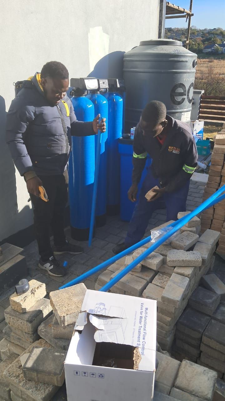 Two men are working on a water filter system.