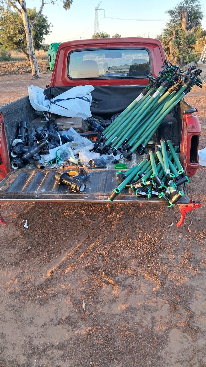 The back of a red truck is filled with lots of equipment.