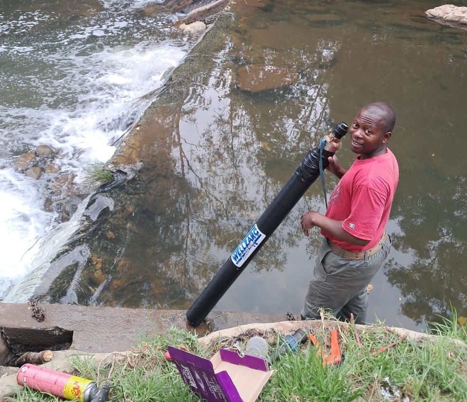 A man in a red shirt is standing next to a river