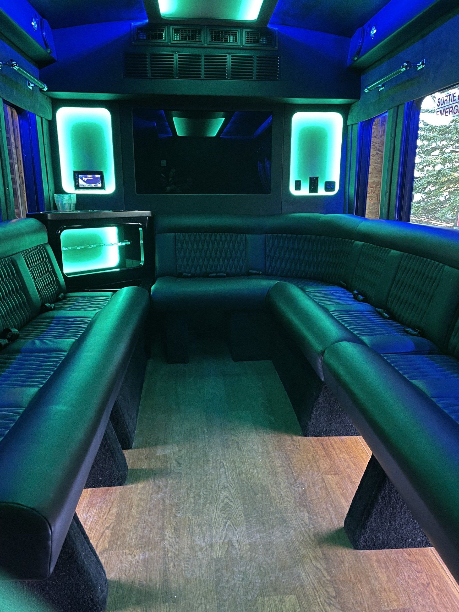 the inside of 2019 Battisti party bus with green LED lights on the walls