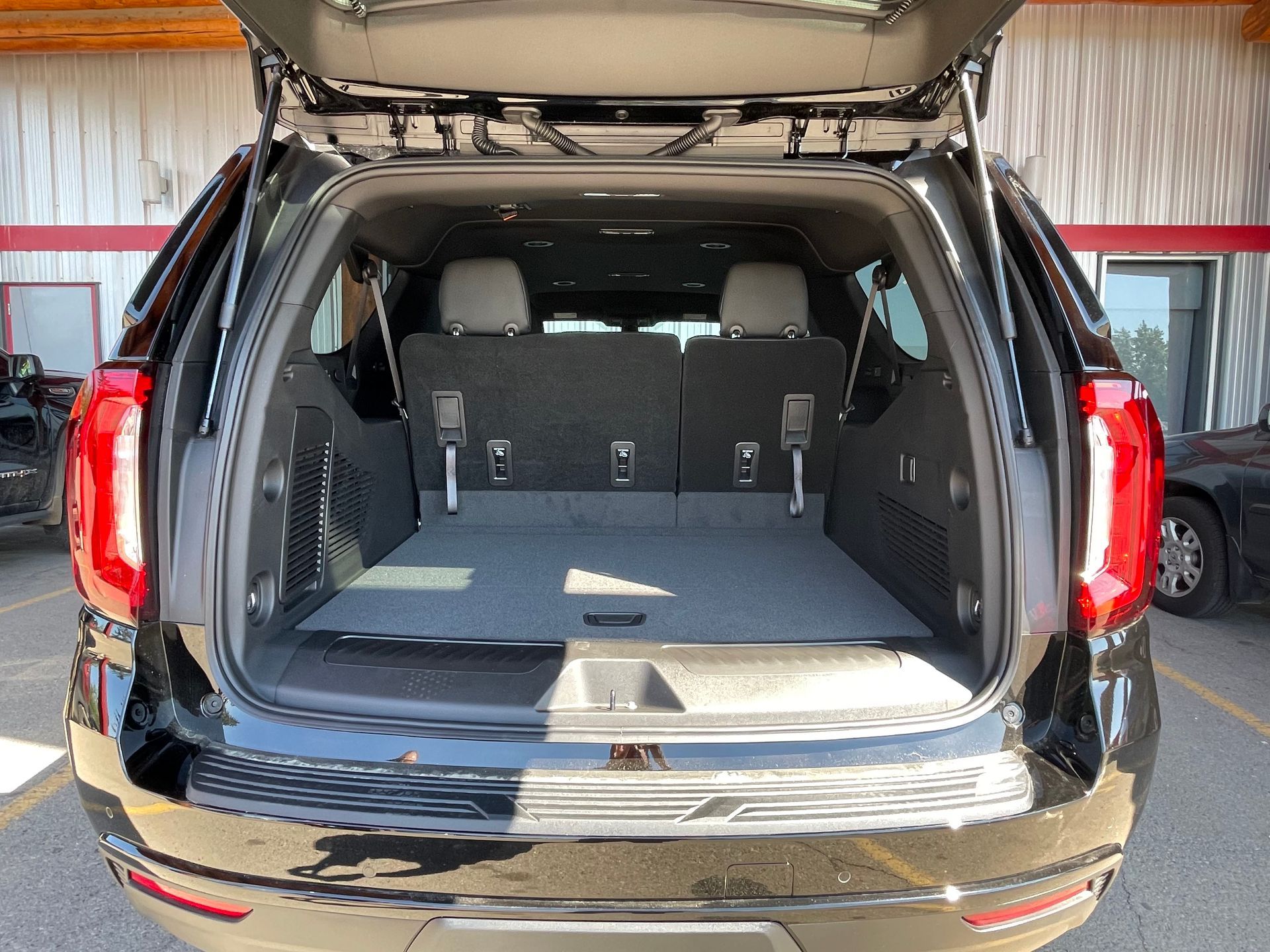 the trunk of a black Yukon suv is open and empty