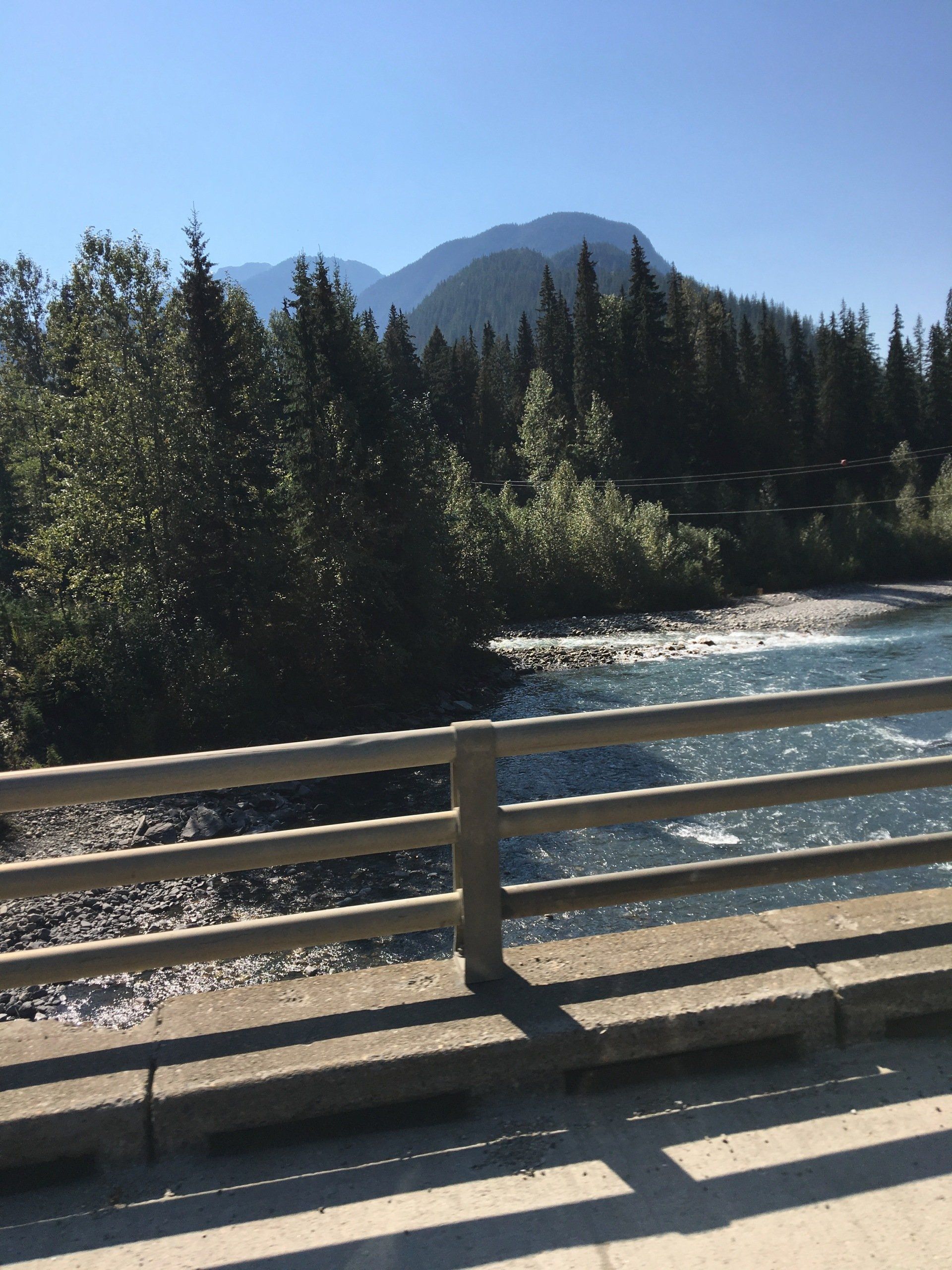 a bridge over a river with mountains in the background